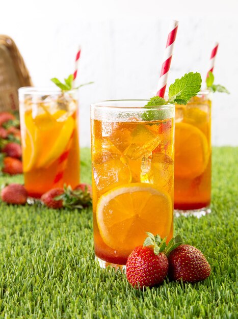 Close-up of strawberry lemon drink in glass on grassy field