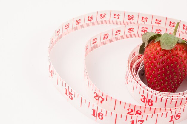 Close up of a strawberry surrounded by a ruler