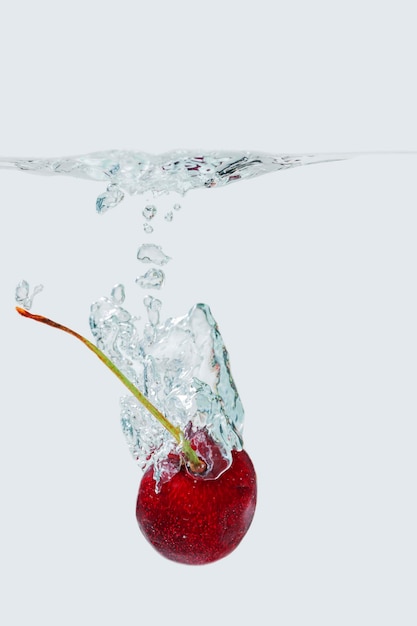 Foto close-up di fragola sopra l'acqua su uno sfondo bianco