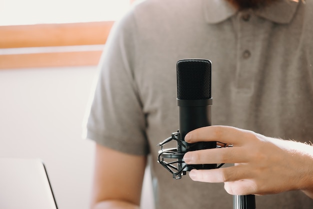 Close up of a streaming microphone while a man holds a phone working streaming