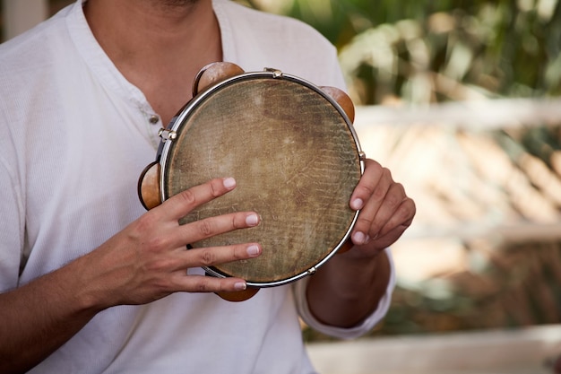 Foto close-up di un musicista di strada che suona il tamburello