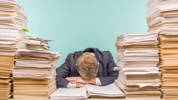 Photo close-up of a stressful businessman tired from his work on the foreground - image