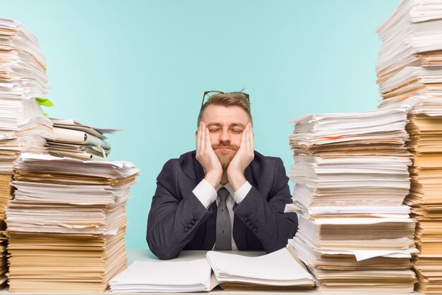 Photo close-up of a stressful businessman tired from his work on the foreground - image