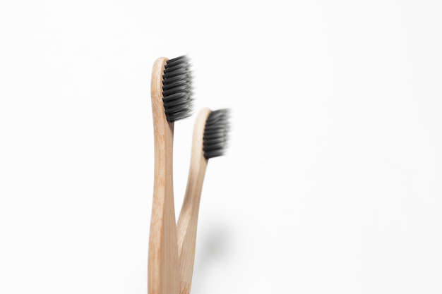 Close-up studio photo of two bamboo toothbrushes, on white.