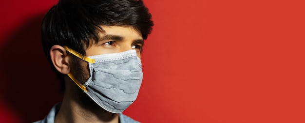 Close-up studio portret van jonge man met medische griep masker