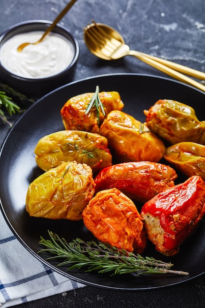 Close-up of stuffed bell peppers with rice, ground beef, and pork baked in tomato sauce, rosemary and thyme