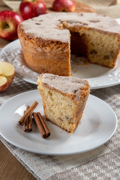 Close-up stuk van Biscuit of chiffon cake met appels zo zacht en heerlijk gesneden met ingrediënten kaneel eieren meel appels op houten tafel Thuis bakkerij concept voor achtergrond en behang