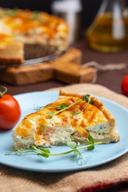 Close-up stukje Franse taart met zalm en kaas Quiche Lauren met rode vis afgesneden stuk