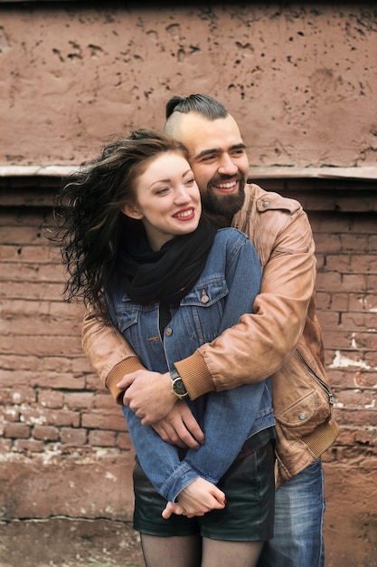 Close up stylish guy hugging his beloved girlfriend