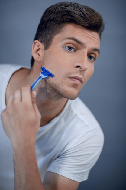 Close up stylish modern guy shaves his facethe concept of personal hygiene