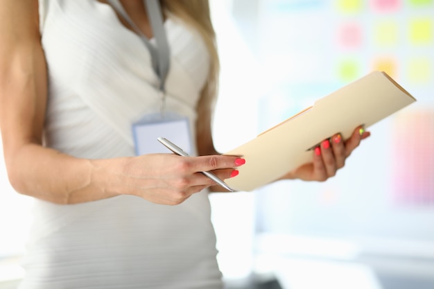 Close-up of stylish woman in white dress preparing for public speaking