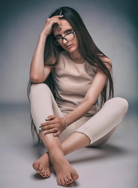 Close up stylish young woman sitting on the floor