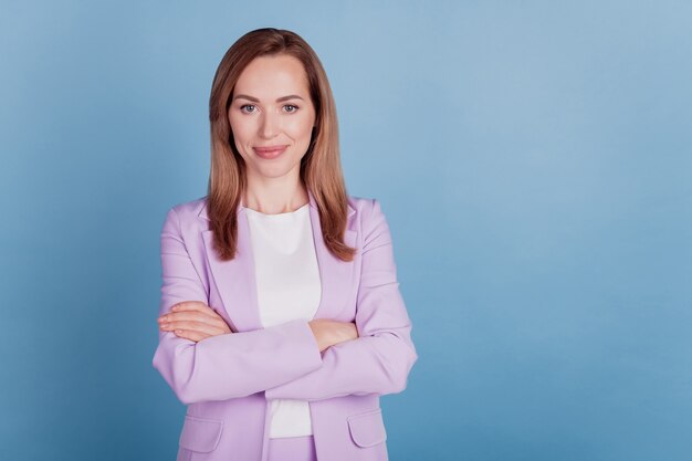 Close-up of a successful business lady manager look camera folded hands on blue background