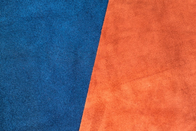 Close up suede navy blue and orange leather divide at half ratio texture background