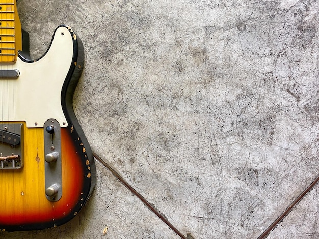 Foto close-up di una chitarra elettrica in stile tele su sfondo di cemento