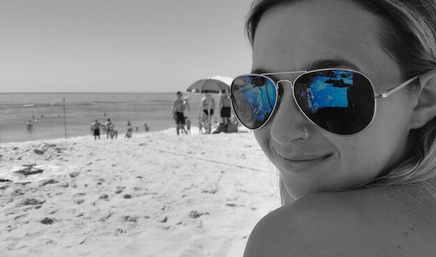 Close-up of sunglasses on beach against sky