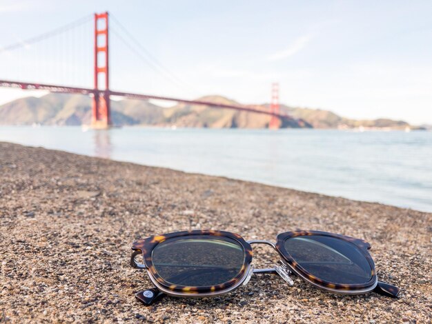 Close-up of sunglasses on beach against sky