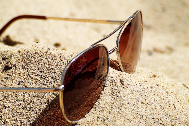 Close-up of sunglasses on beach