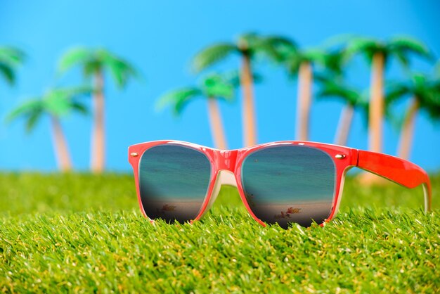 Photo close-up of sunglasses on grass against sky