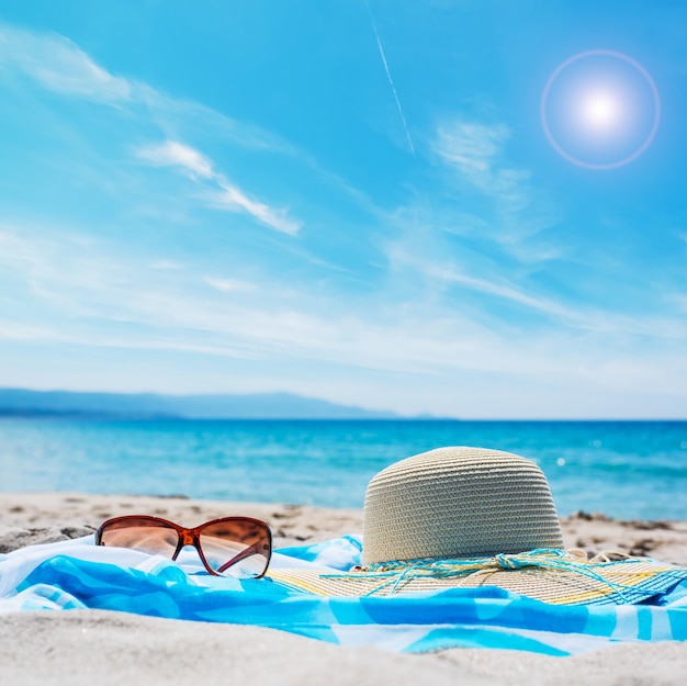 Крупный план солнцезащитных очков и соломенной шляпы на пляже