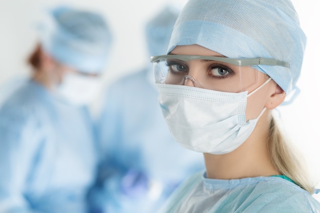 Close-up of surgeon woman looking with colleagues performing in operation room