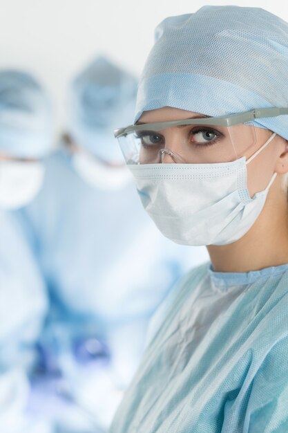 Close-up of surgeon woman looking with colleagues performing in operation room