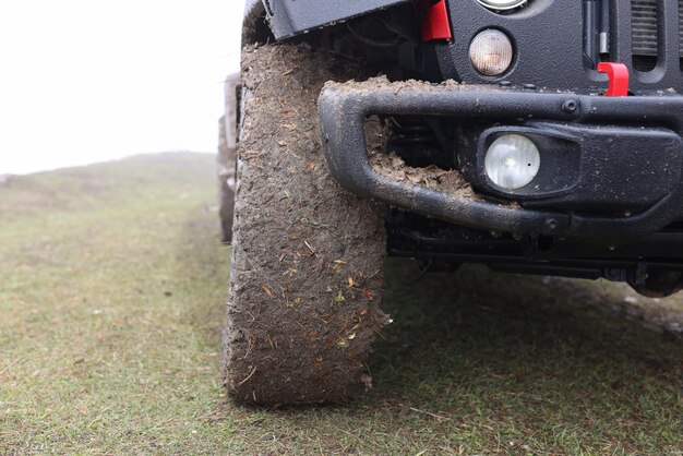 Close up of suv car with dirty wheels in field