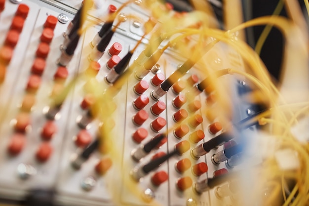 Close up of switchboard with plugs and wires in server room at data center background, copy space