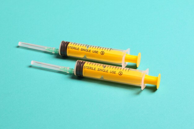 Close-up of syringe on blue background