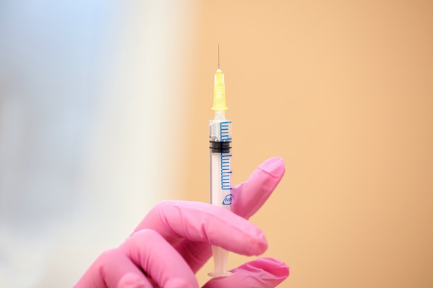 Close-up of syringe in doctor's hand. 