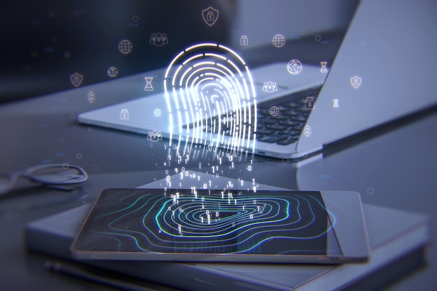 Close up of tablet and laptop on desktop with supplies and\
glowing digital fingerprint hologram digital id safety and\
authentication concept double exposure