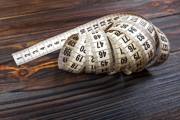 Close up tailor measuring tape on wooden table. 