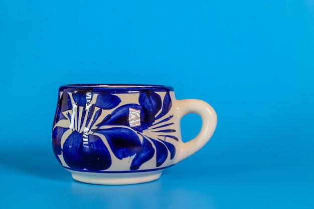 Foto un primo piano di una tazza talavera con uno sfondo blu