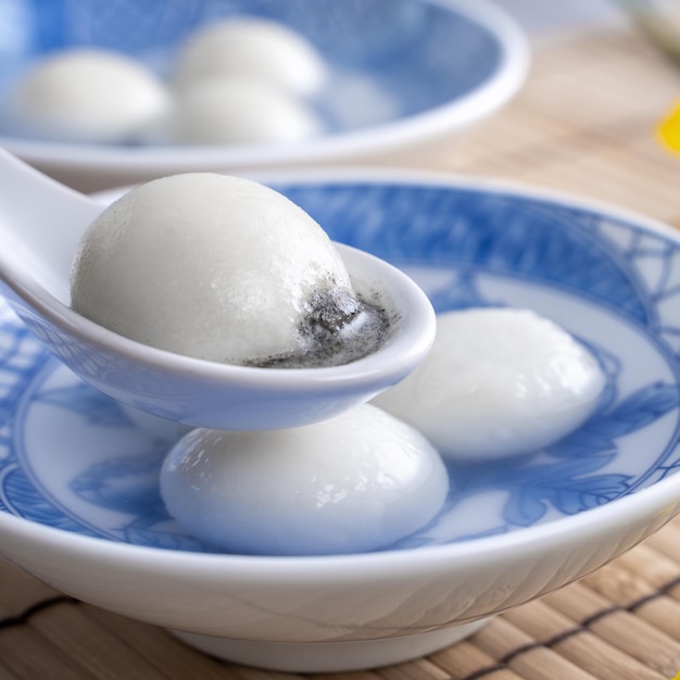 Primo piano di tangyuan in una ciotola sul cibo da tavola grigio per il solstizio d'inverno