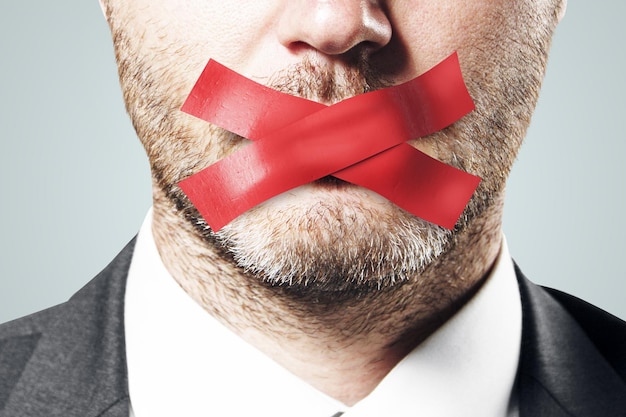 Close up of taped european businessman mouth Silence and speech censorship concept