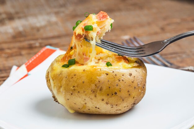 Close-up of tasty potato with a fork