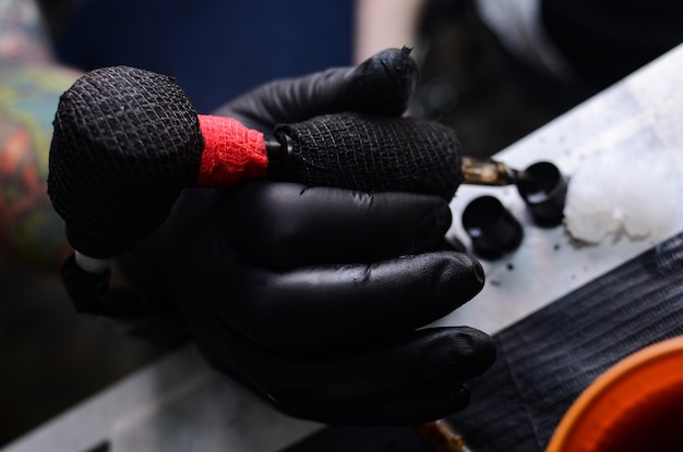 Close-up of tattoo machines and hands