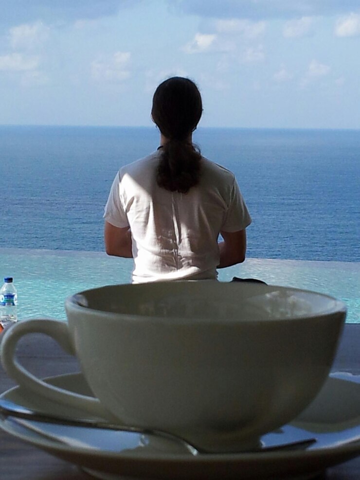 Photo close-up tea cup behind man standing in front of sea