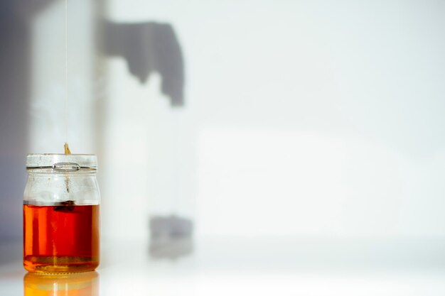 Photo close-up of tea in jar against white wall