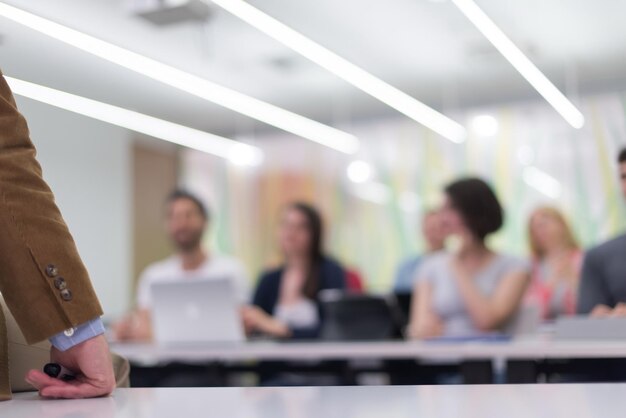 Foto primo piano della mano dell'insegnante con un pennarello durante l'insegnamento delle lezioni in classe agli studenti