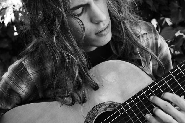 close-up of teenage boy playing guitar