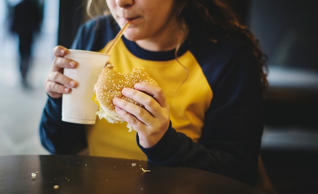 Photo close up of teenage girl eating hamburger obesity concept