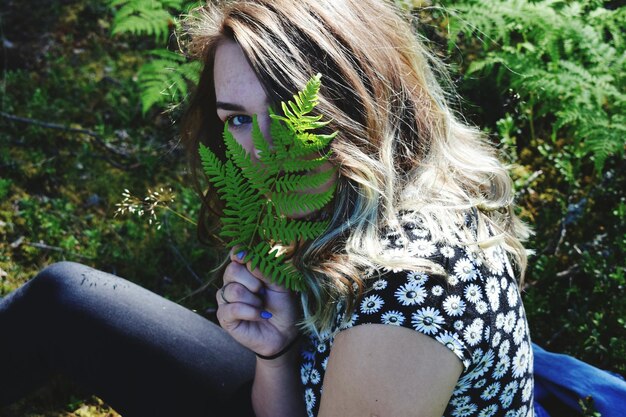 Photo close-up of teenage girl with fern at park