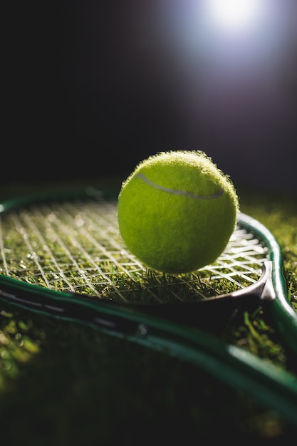 Chiuda in su della sfera di tennis con la racchetta