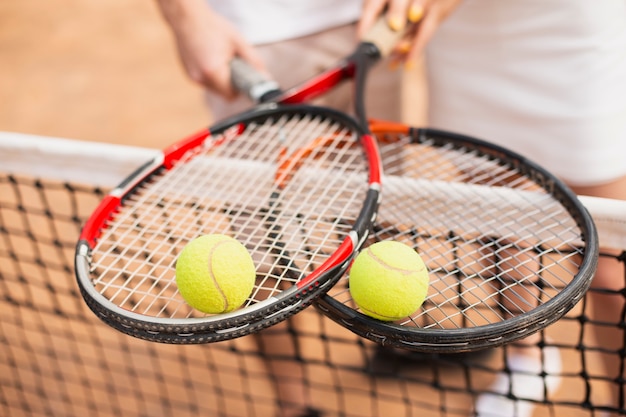 Palline da tennis del primo piano sopra le racchette