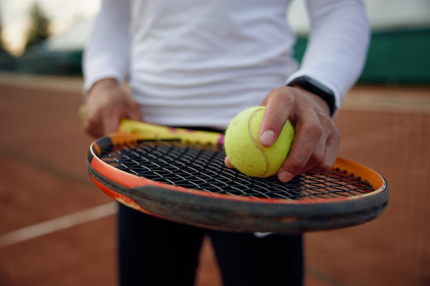 Close up of tennis player holding ball on racket for serving