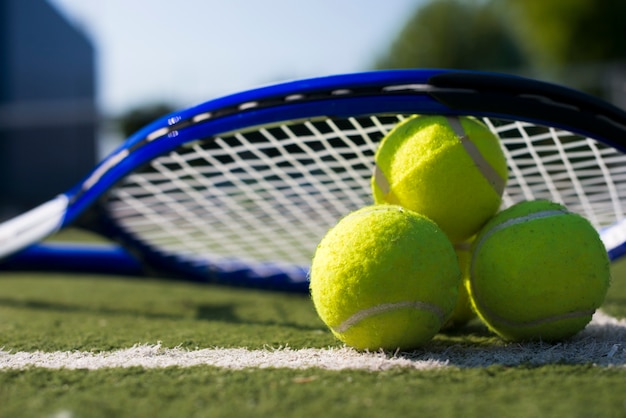 Close-up tennis rocket over balls