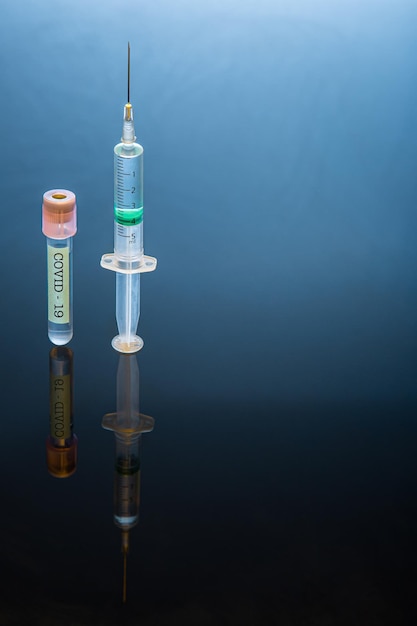 試験管と注射器のクローズアップとCOVID-19ワクチン