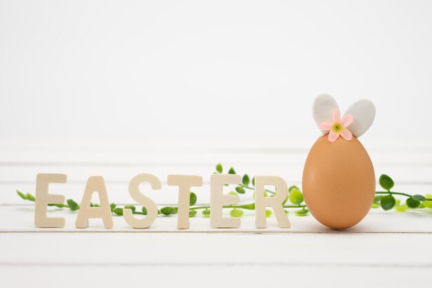 Close-up of text by easter egg on table against white background