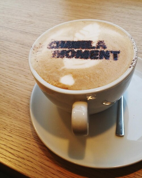 Close-up of text on cappuccino served on table